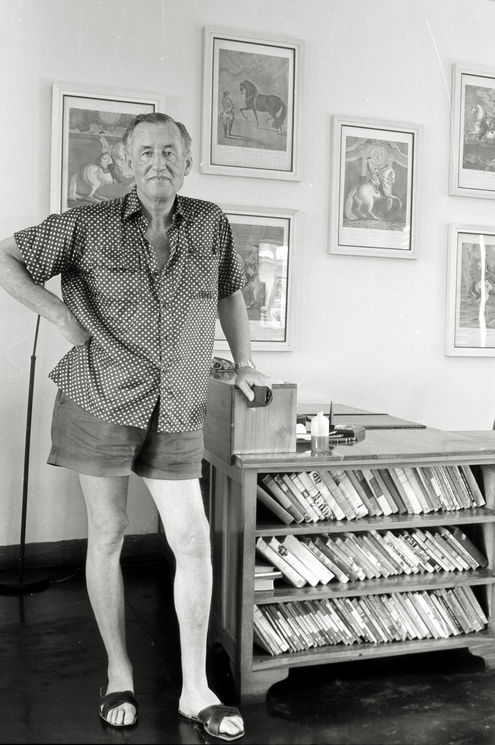 Ian Fleming samen met een aantal eerste edities boeken die hij verzamelende